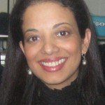 A close up of a woman wearing earrings and smiling.